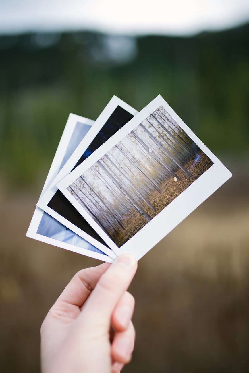 Printed photographs held in a hand