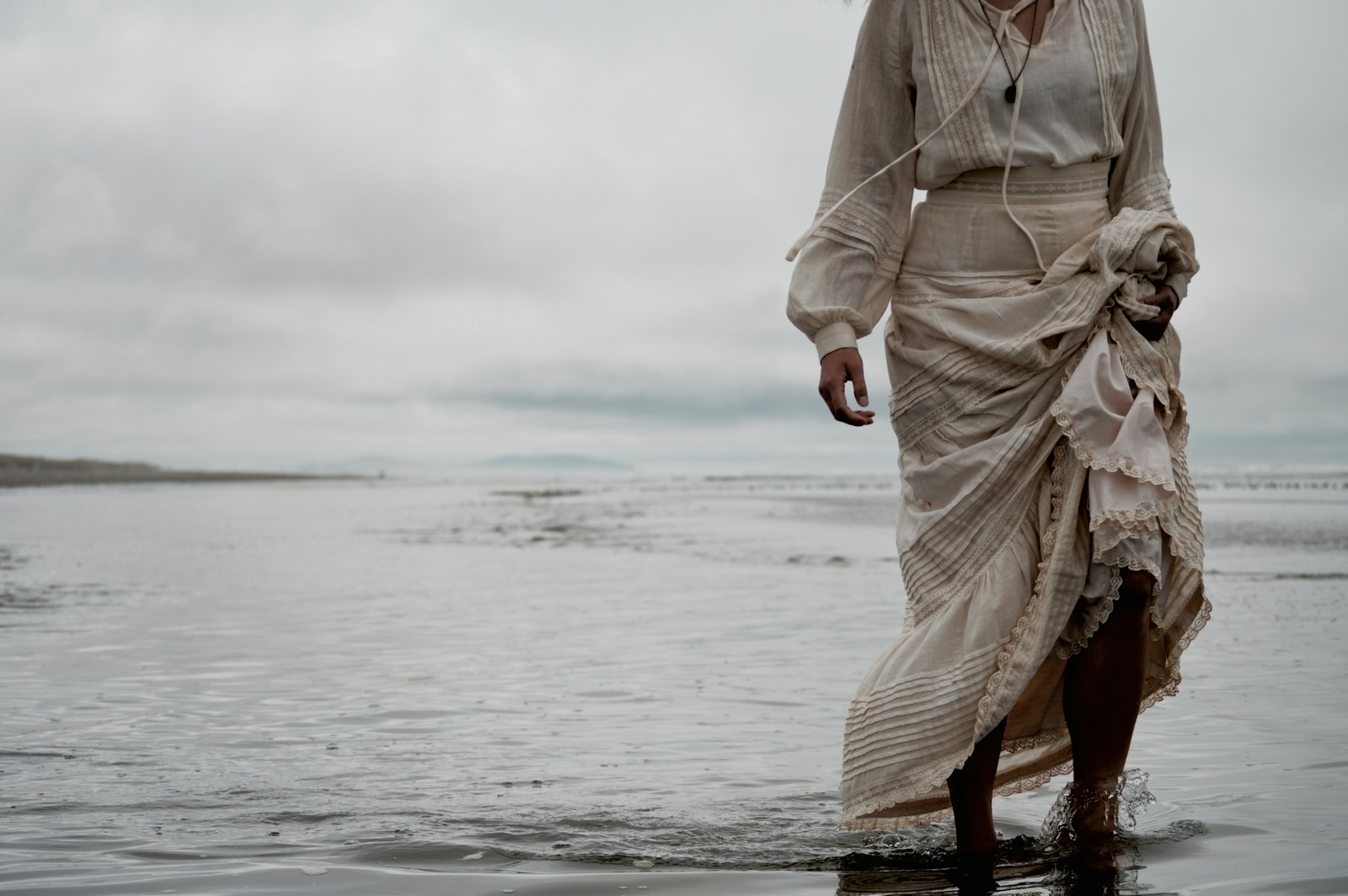 Standing at the shoreline in a linen skirt