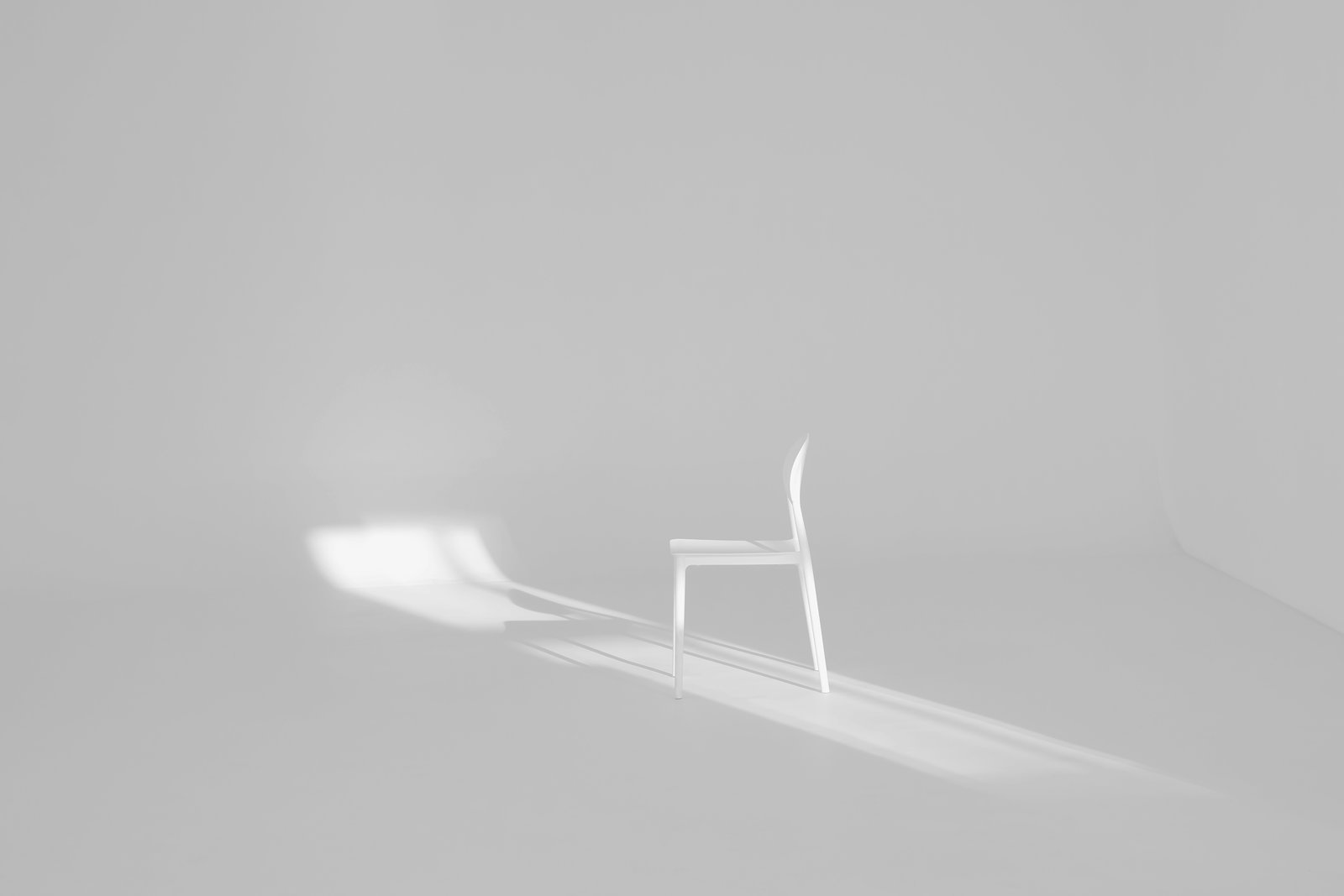 A white chair with a long shadow